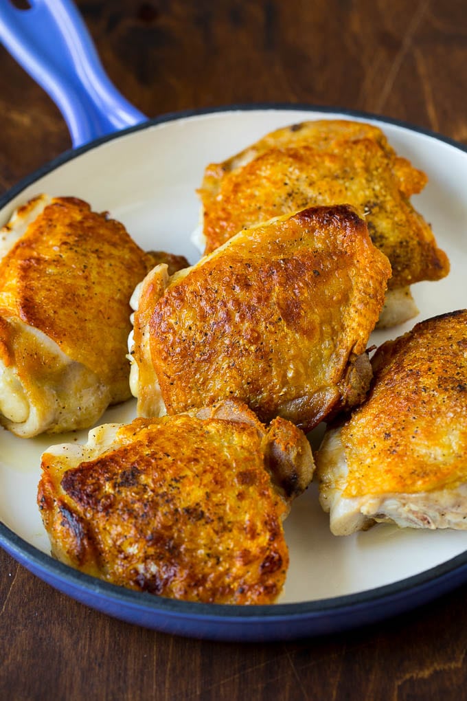 Seared chicken thighs in a skillet.