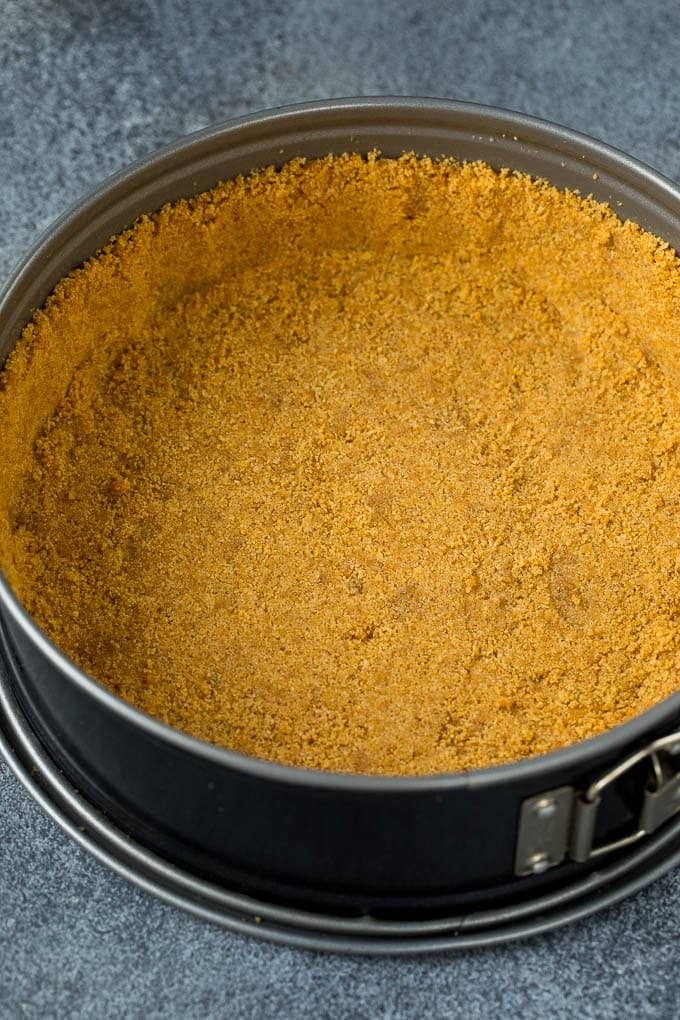 Graham cracker crust in a springform pan.