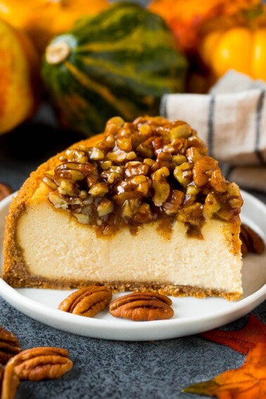 A slice of pecan pie cheesecake on a serving plate.