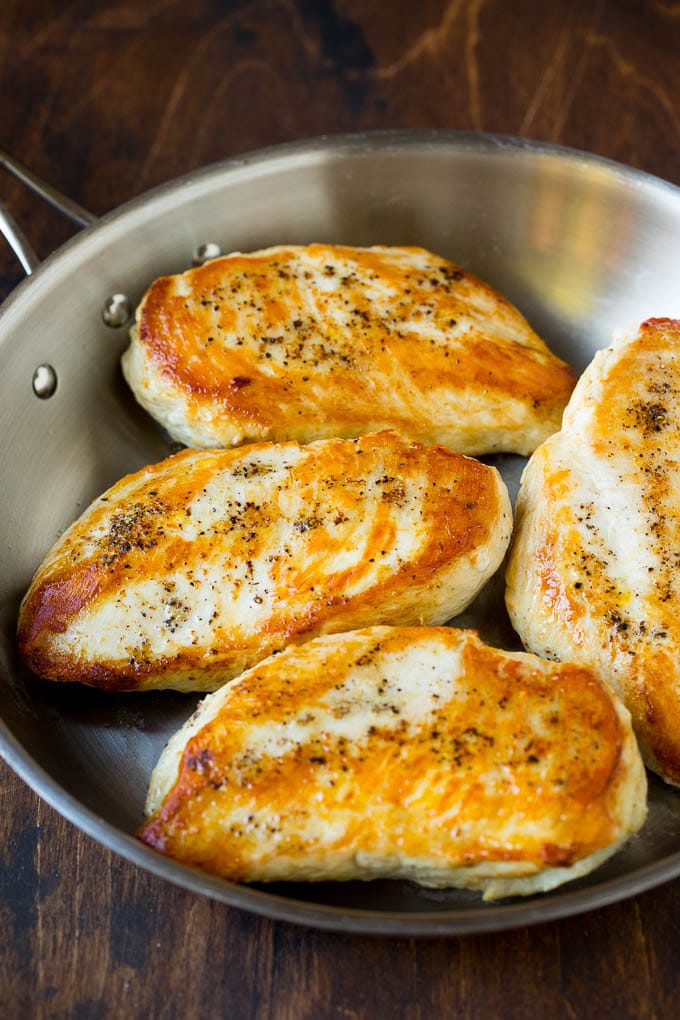 Seared chicken breasts in a pan.