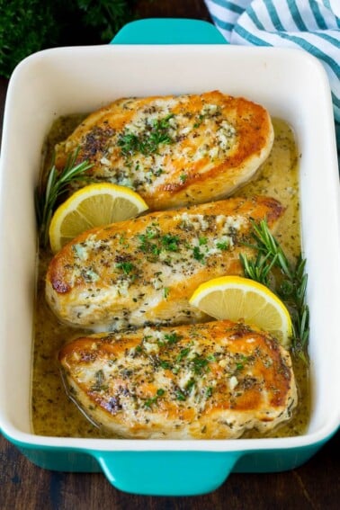 Baked rosemary chicken in a lemon sauce, garnished with fresh herbs.