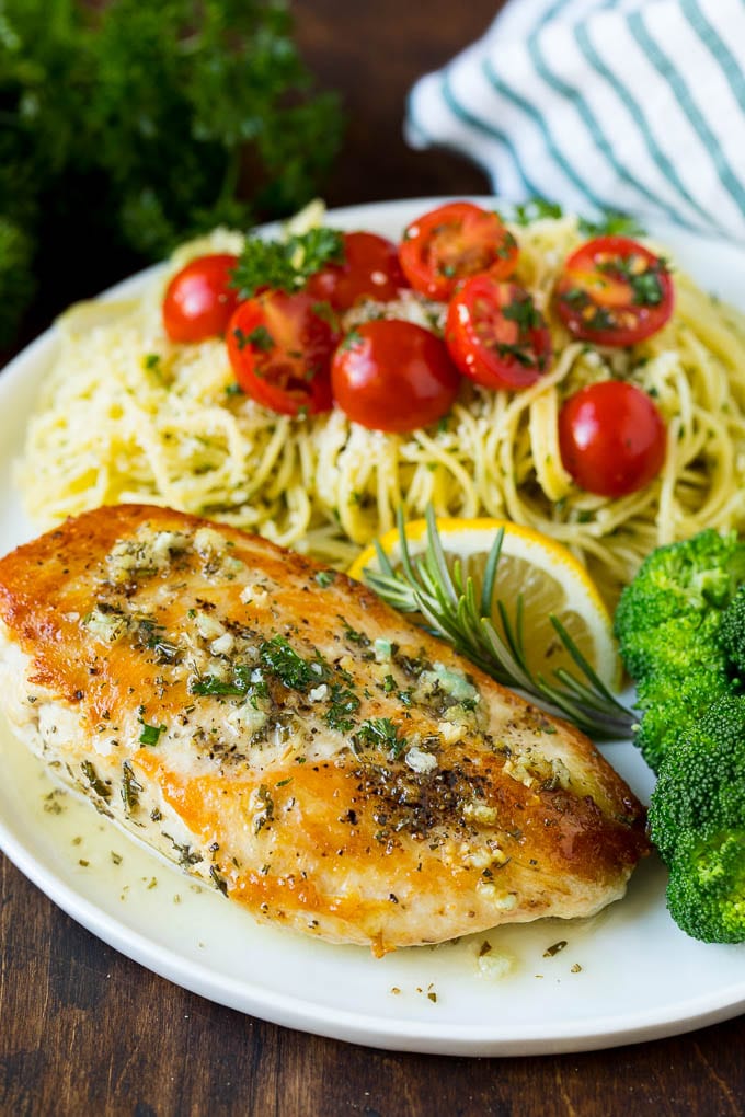 Rosemary chicken on a plate with pasta and broccoli.