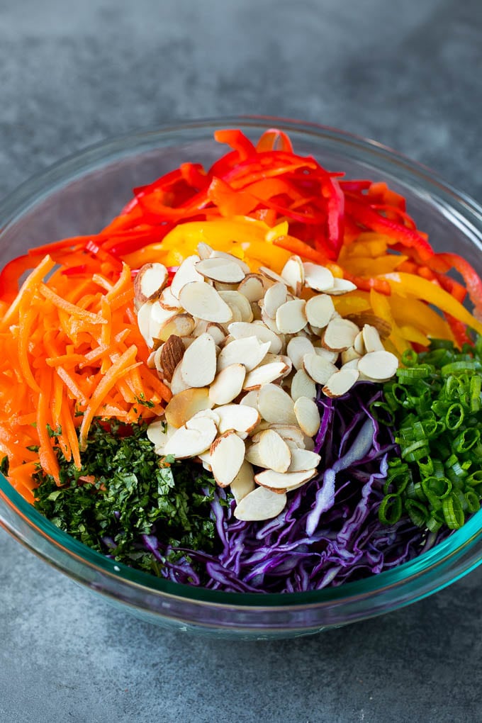 Shredded cabbage, vegetables and almonds in a bowl.