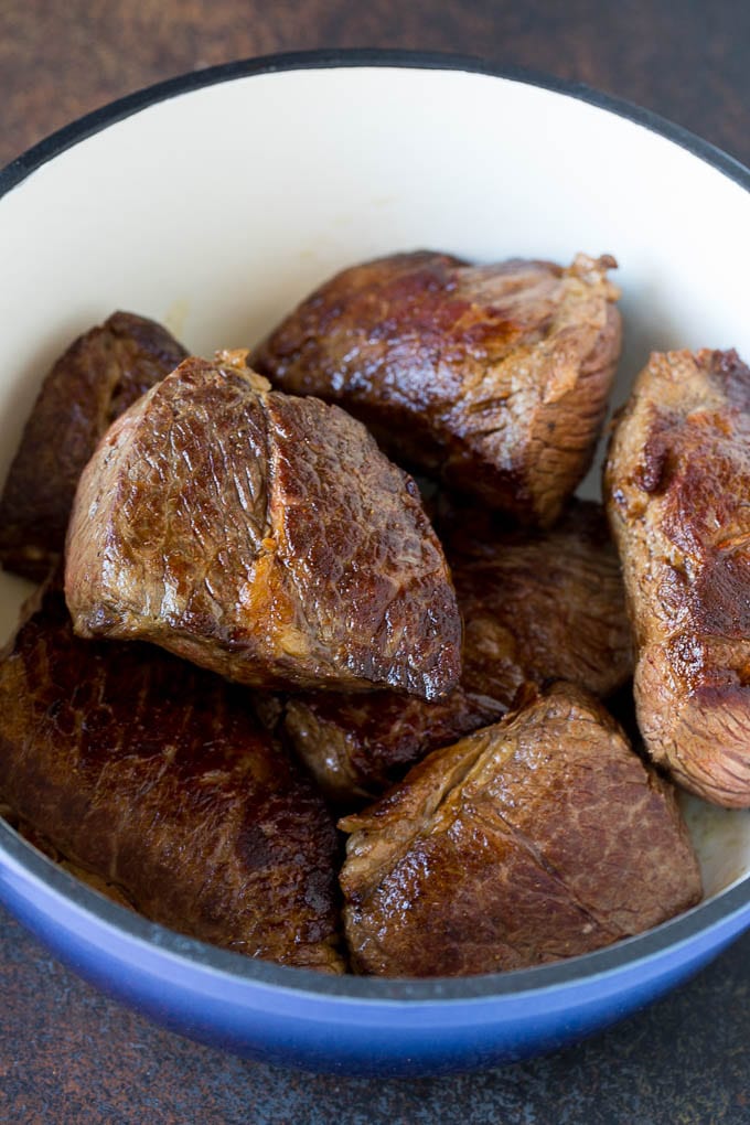 Seared boneless short ribs in a pot.