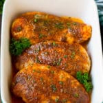 Baked Cajun chicken garnished with fresh parsley.