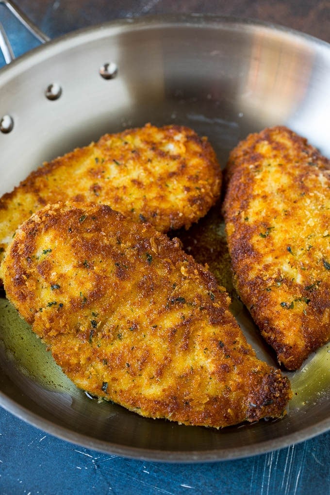 Golden brown pan fried chicken breasts.
