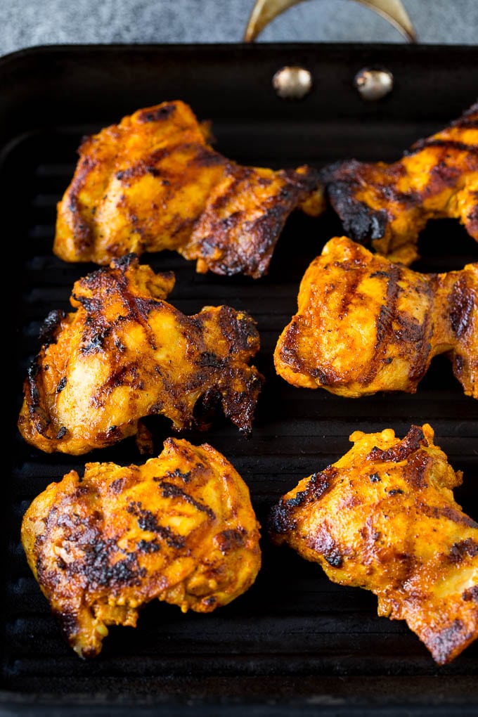 Cooked chicken thighs on a grill pan.