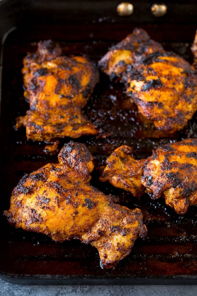 Cooked chicken thighs on a grill pan.