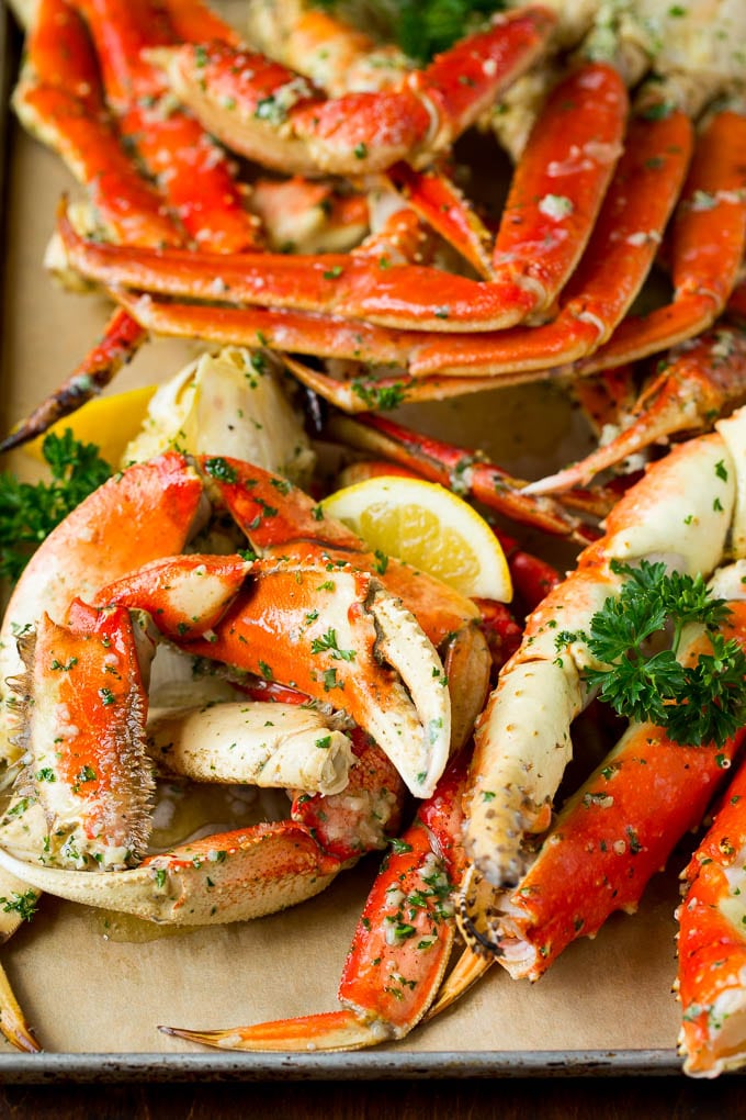 A tray of crab legs seasoned with garlic and herbs.