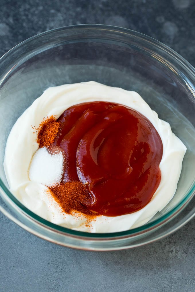 Mayonnaise, ketchup and spices in a mixing bowl.