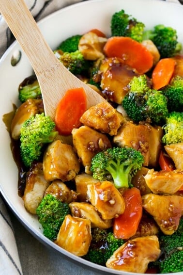 A pan of honey garlic chicken stir fry with a spatula in it.