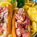 A plate of lobster roll served with chips.