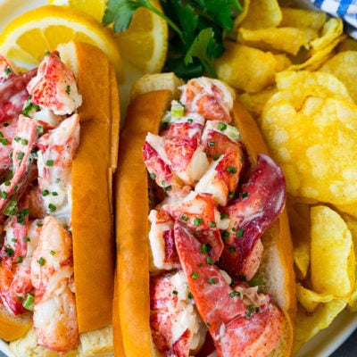 A plate of lobster roll served with chips.