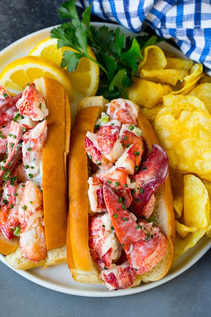 A lobster roll filled with a creamy seafood mixture and served with chips.