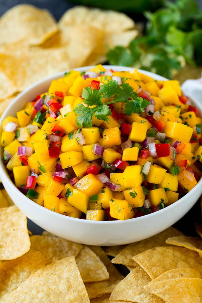 A bowl of mango salsa served with tortilla chips.