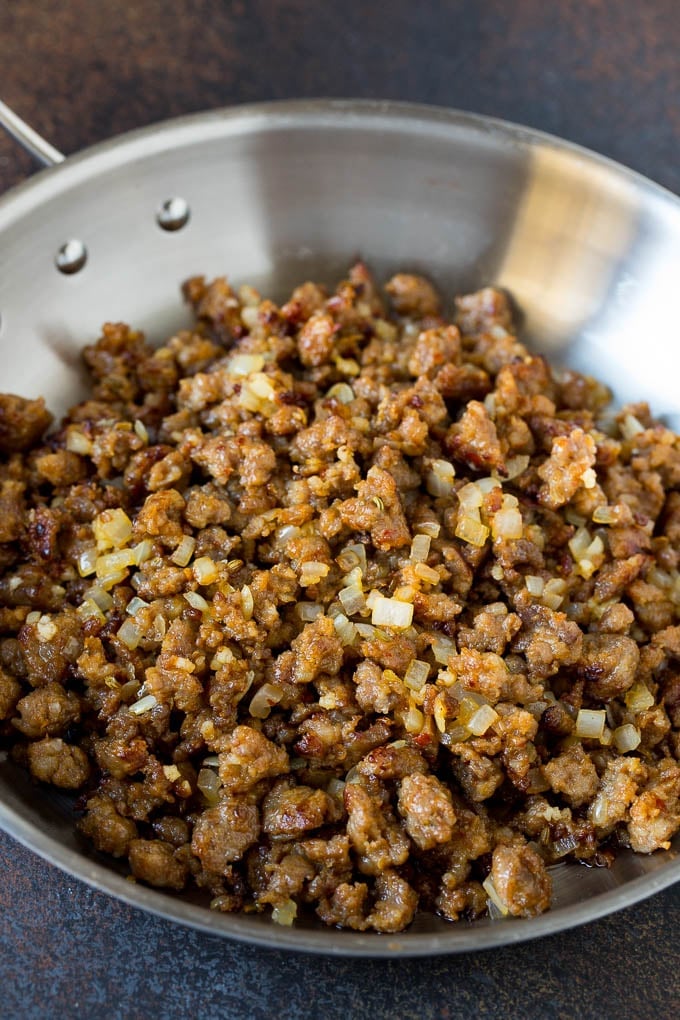 Sausage and onions cooked together in a skillet.