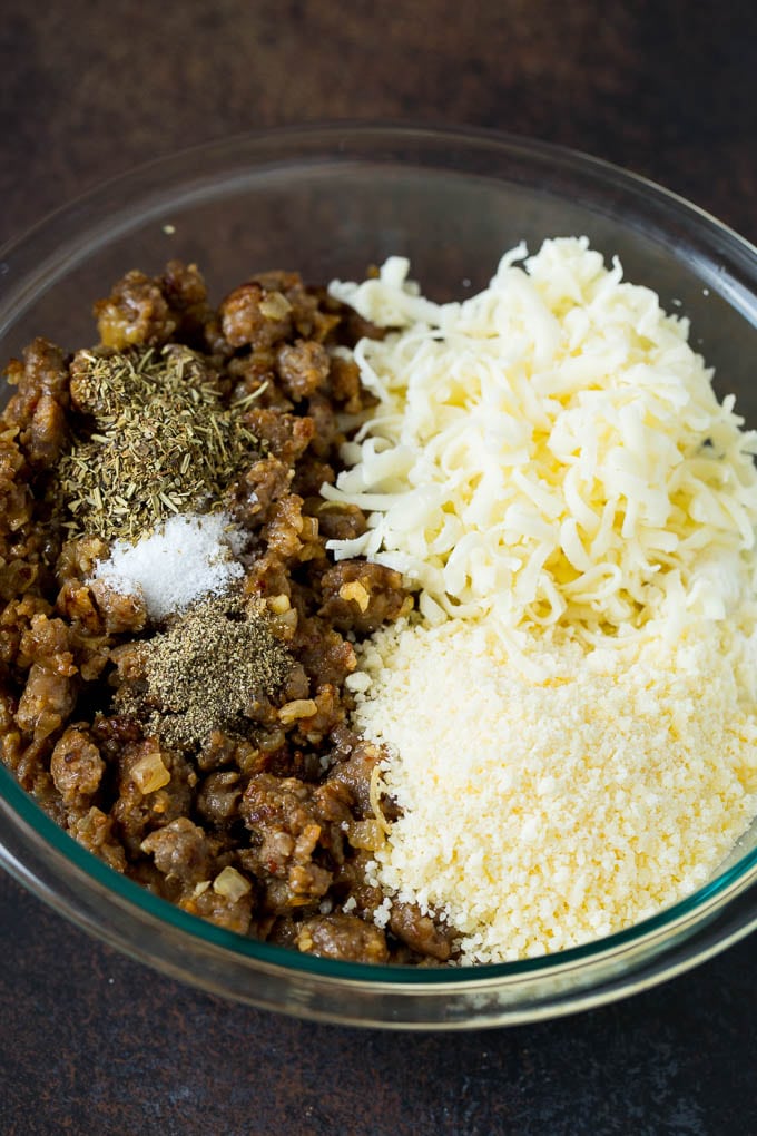 Sausage, cheeses and herbs in a mixing bowl.