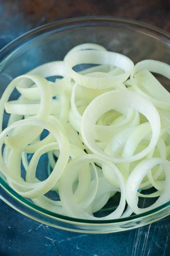 Raw onion slices in a bowl.