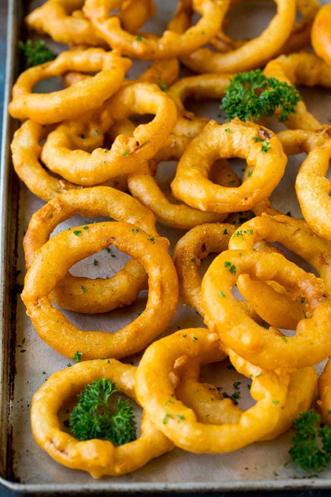 Beer battered onion rings on a sheet pan.