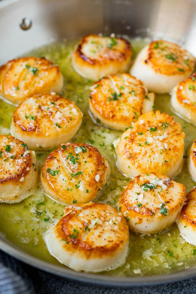 A pan of scallops in garlic butter.