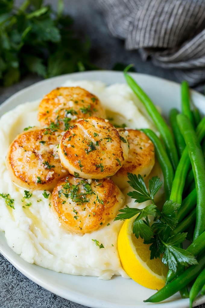 Seared scallops served with mashed potatoes and green beans.