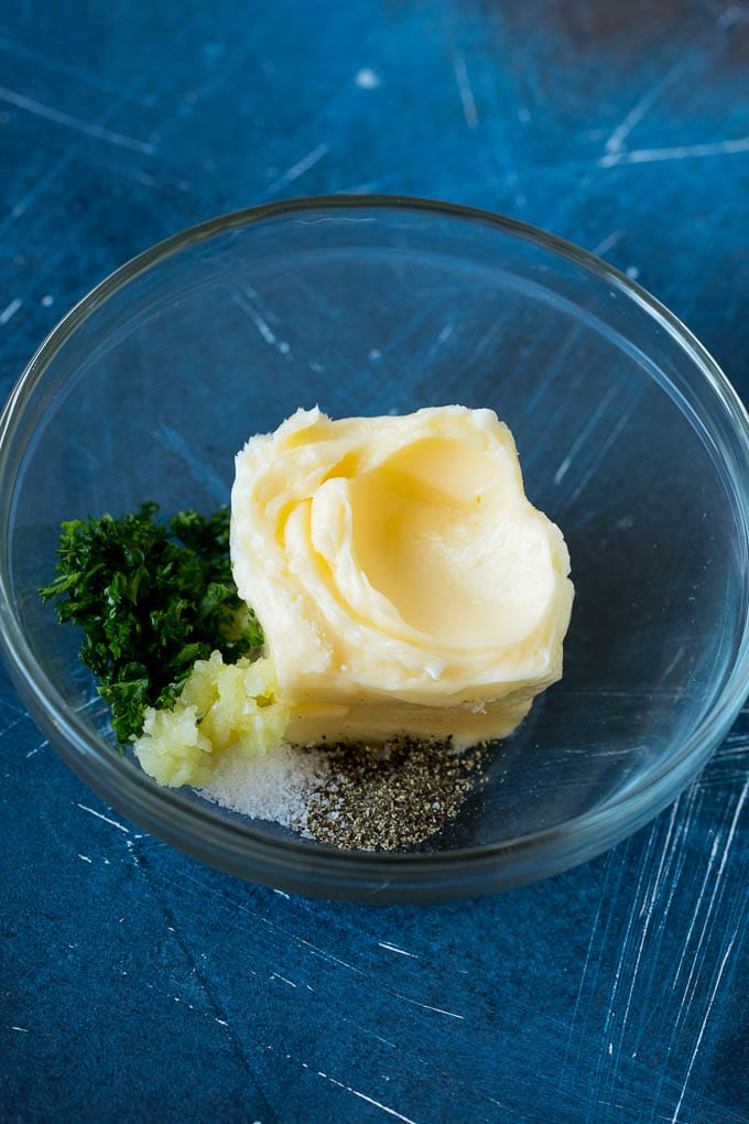 Butter, garlic and herbs in a mixing bowl.