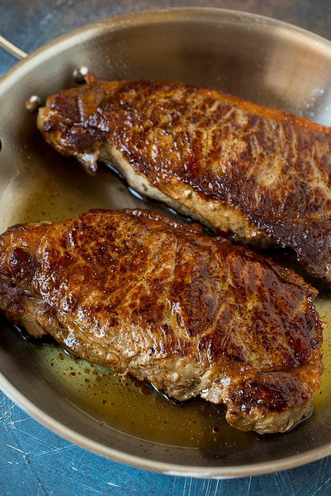 Seared steaks in a pan.