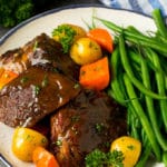 Slow cooker pot roast served with carrots, potatoes and green beans.