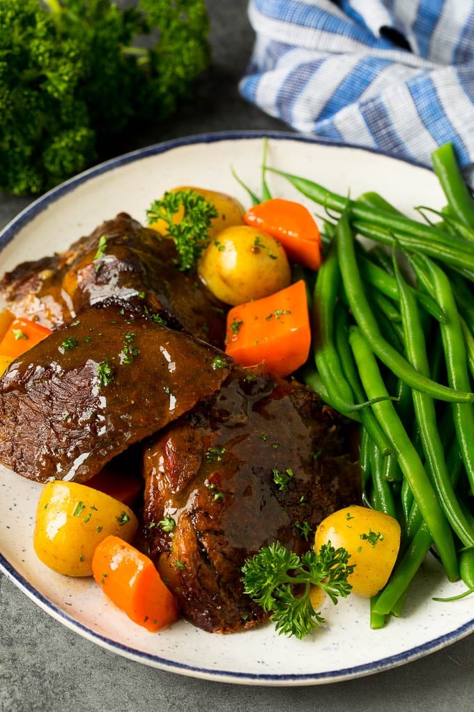 Slow cooker pot roast served with carrots, potatoes and green beans.