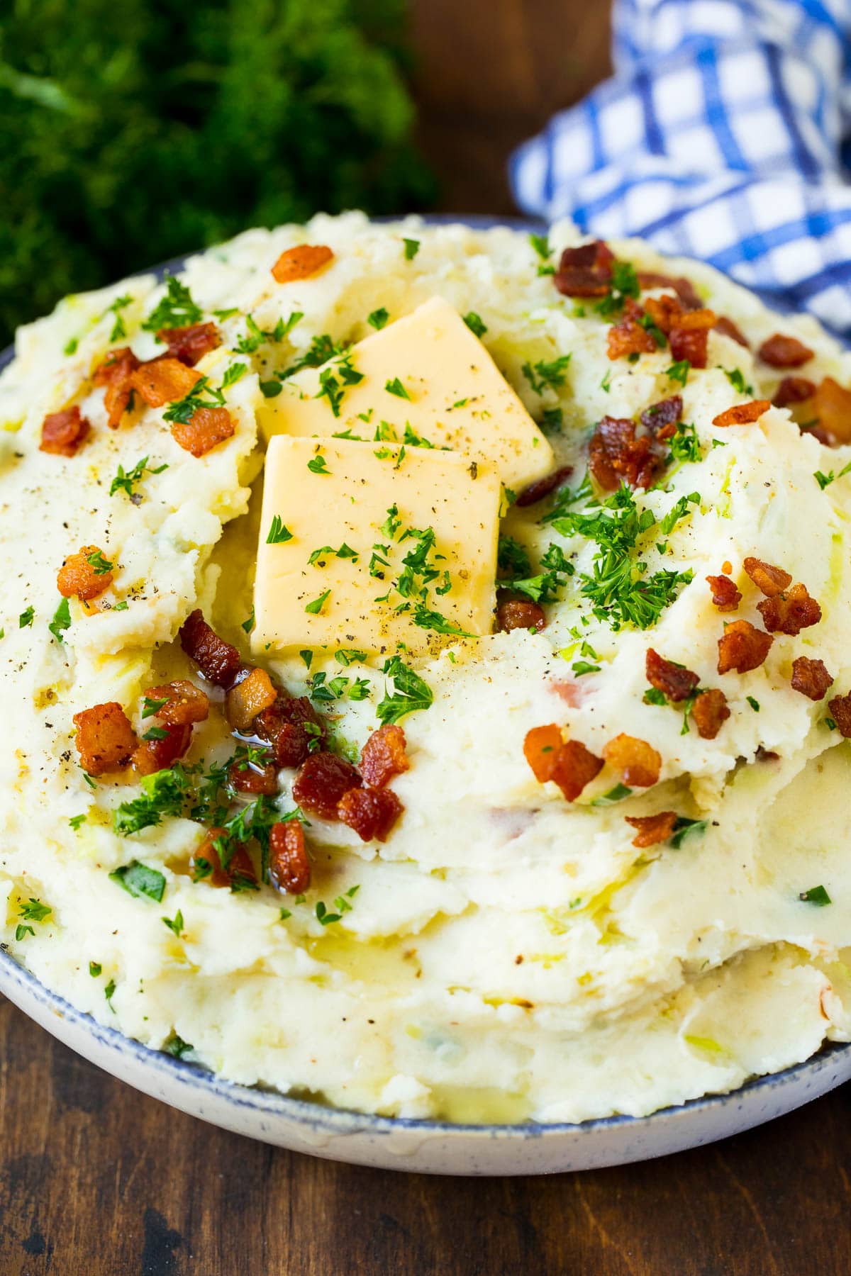 A serving bowl of colcannon topped with butter and herbs.