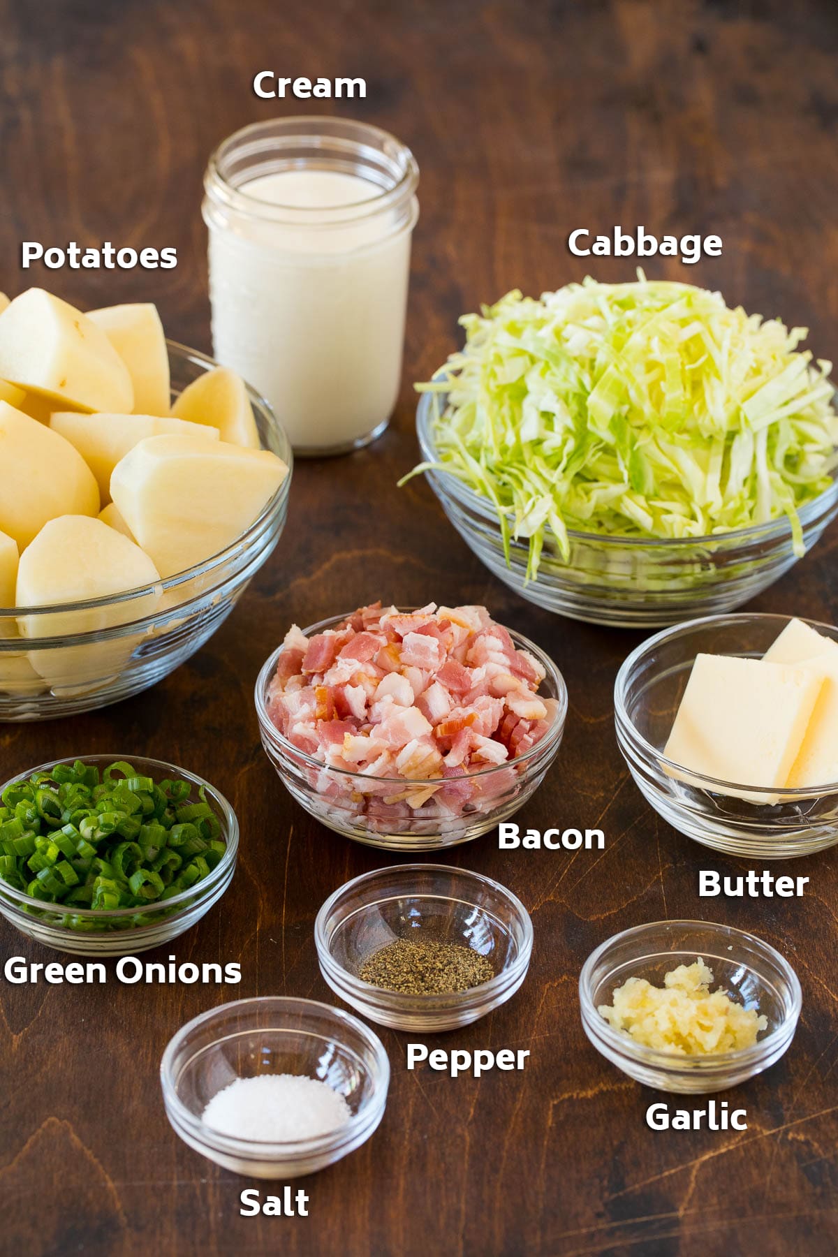 Bowls of bacon, cabbage, potatoes, and seasonings.