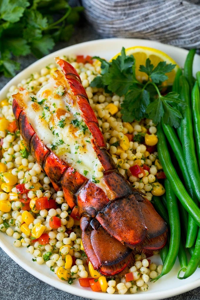 Grilled lobster tail served with couscous and green beans.