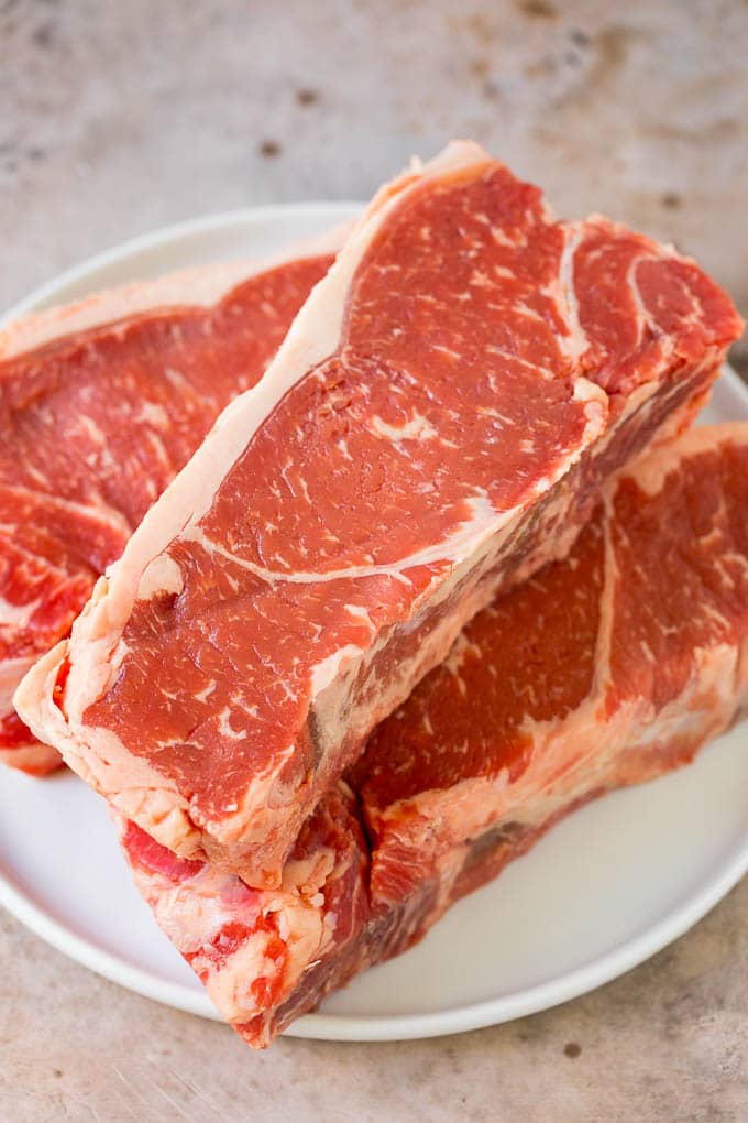 Raw steaks on a plate.