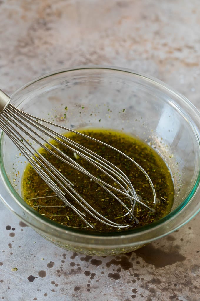 Salad dressing with a whisk in a bowl.