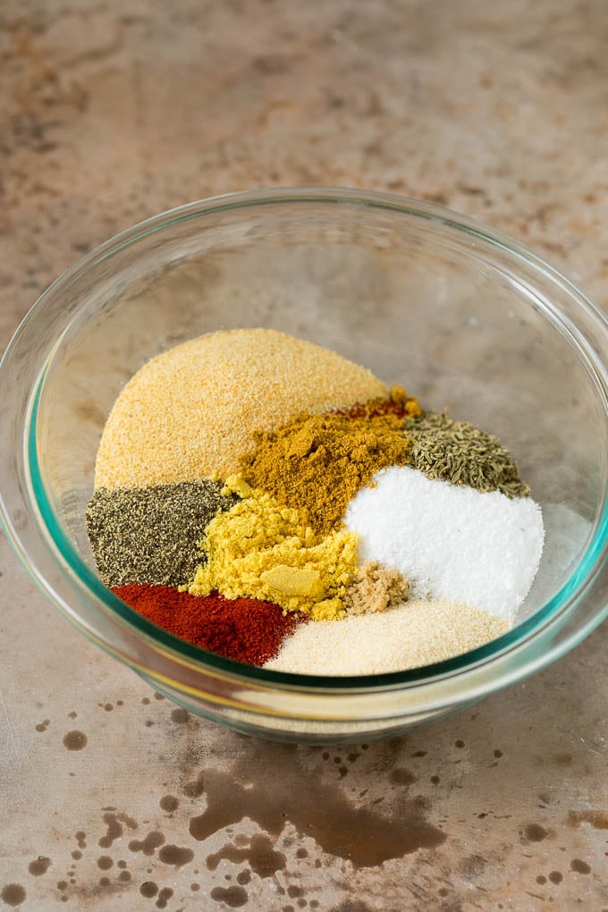 A bowl with a variety of herbs and spices inside.