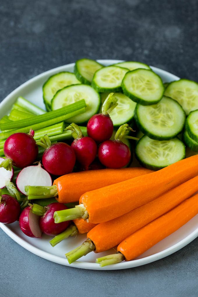 Carrots, celery, radishes and cucumber on a plate.