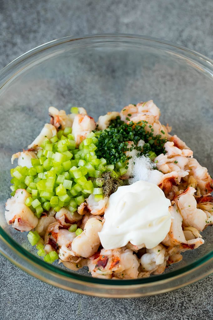 Diced lobster, celery, mayonnaise and chives in a bowl.