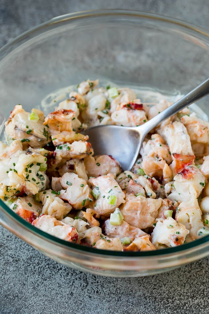 A mixing bowl filled with lobster tossed in dressing.