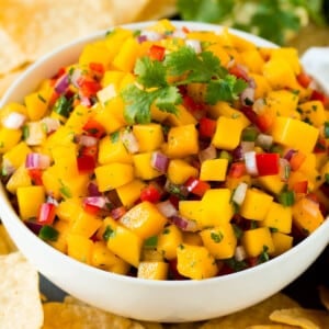 A bowl of mango salsa served with tortilla chips.