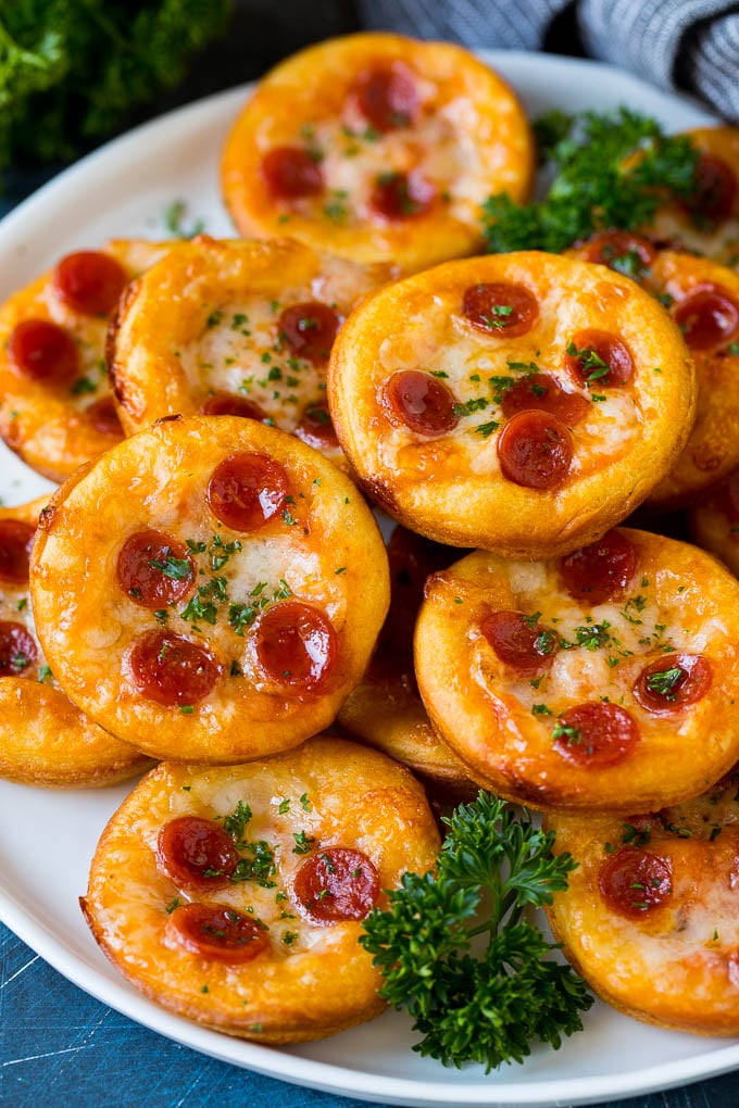Mini pizzas topped with melted cheese and pepperoni.