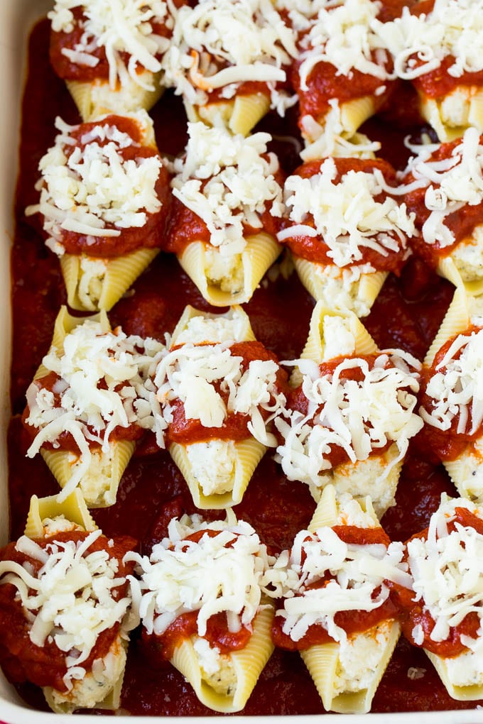 Filled pasta shells topped with marinara sauce and shredded cheese.