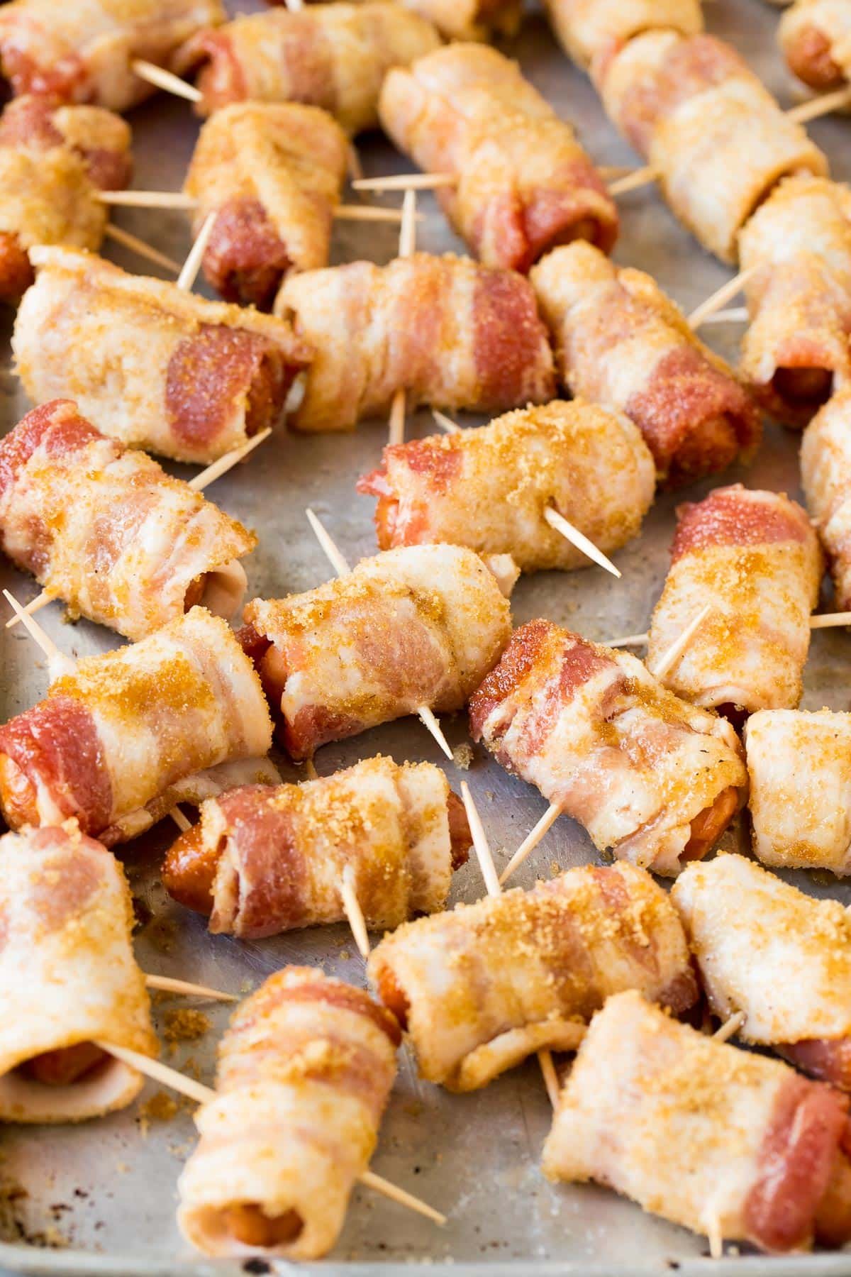 Sausages wrapped in bacon and secured with toothpicks.