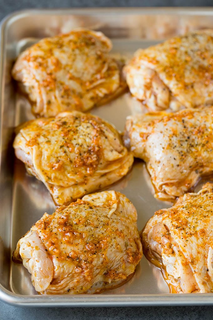 Marinated chicken thighs on a sheet pan.