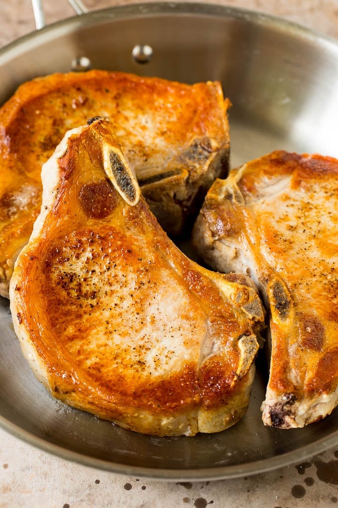 Seared pork chops in a skillet.