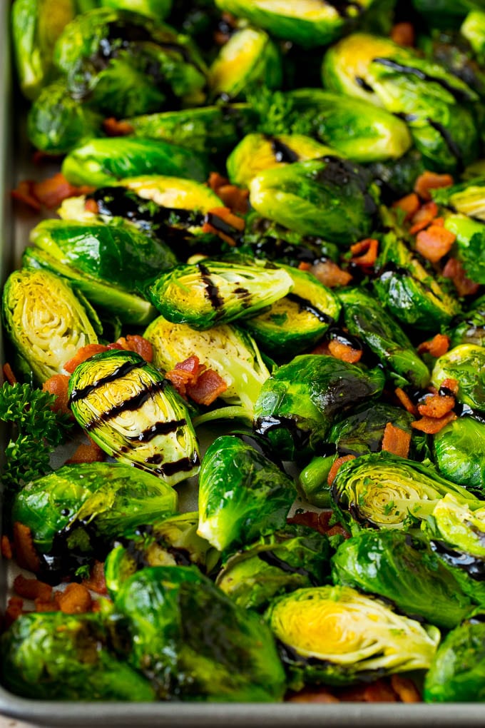 Balsamic brussels sprouts with crispy bacon and parsley on a pan.