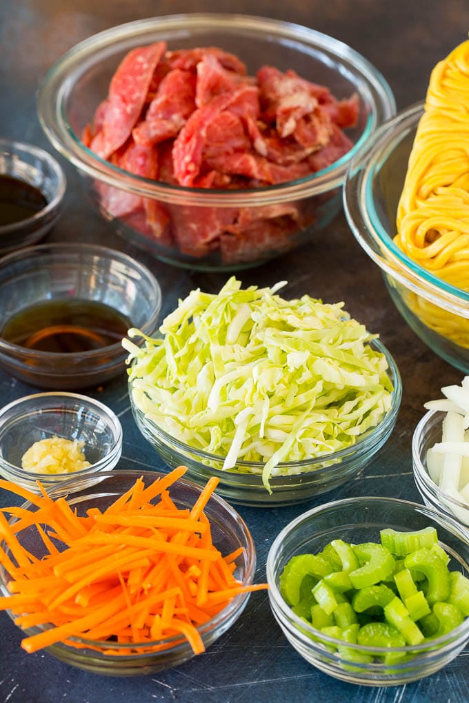 Bowls of ingredients including steak, carrots, celery, cabbage and noodles.