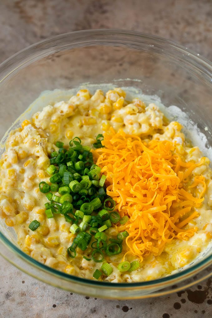 Corn batter topped with green onions and shredded cheese.