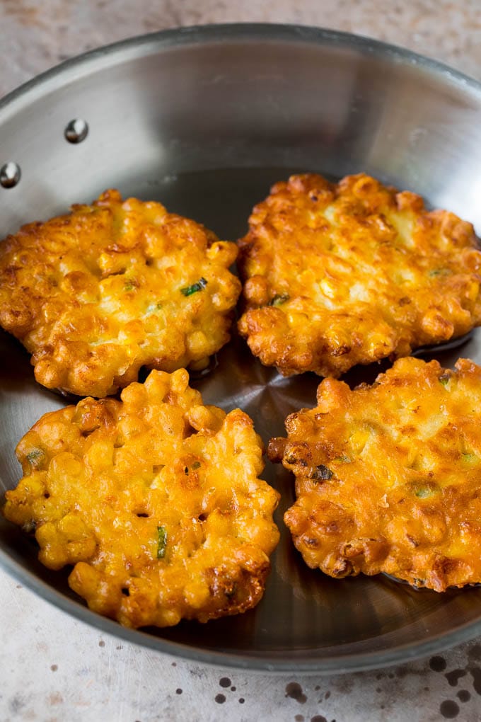 Corn cakes in a pan of oil.