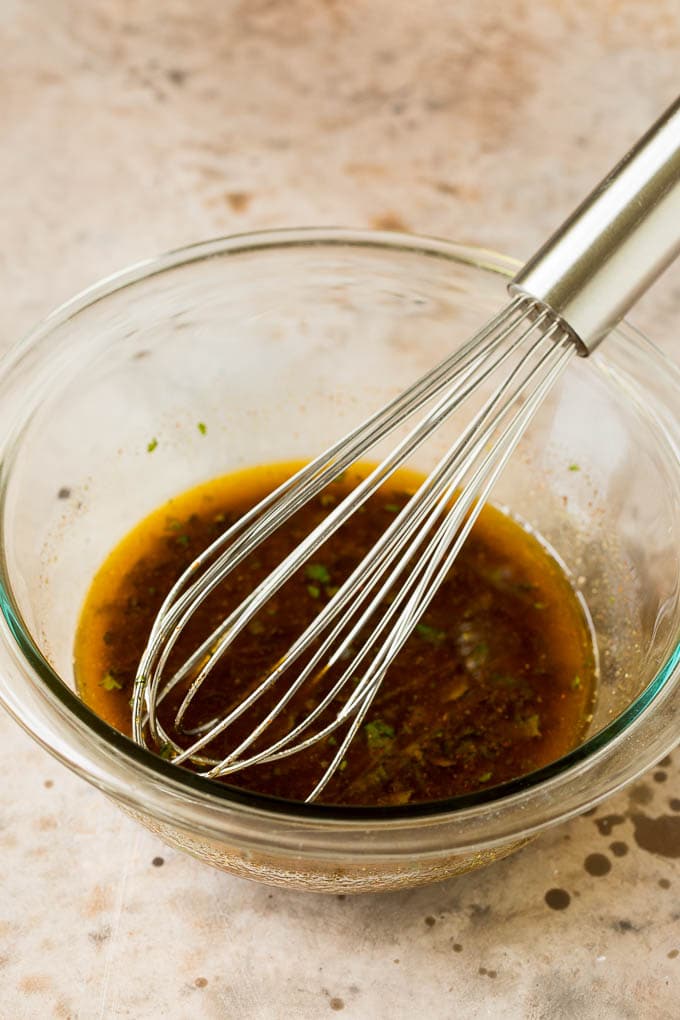 Homemade salad dressing in a bowl with a whisk.