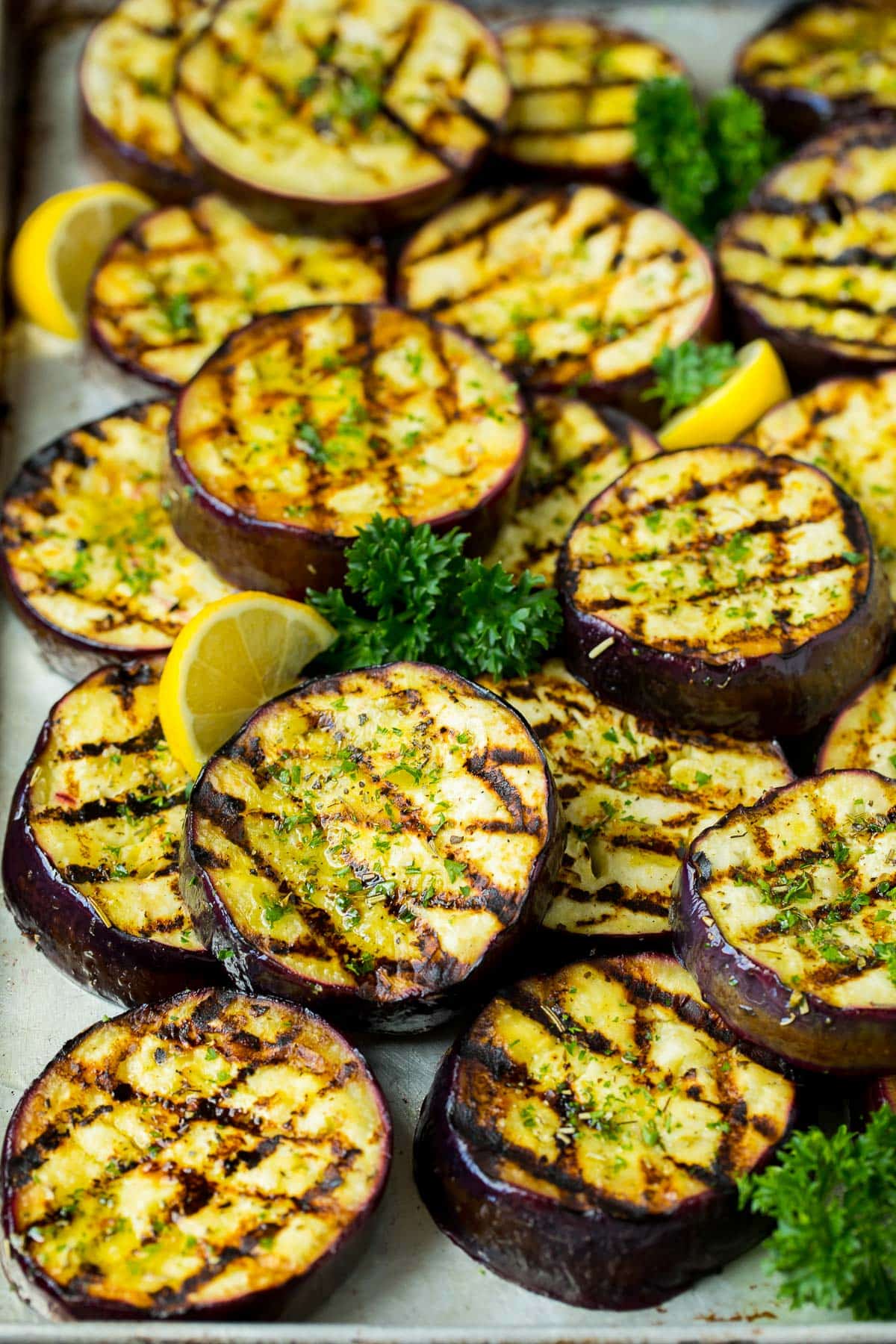 A pan of grilled eggplant slices topped with parsley.